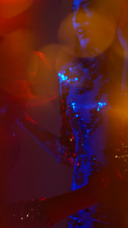 Vertikales-Video-Von-Zwei-Frauen,-Die-In-Einer-Nachtclubbar-Oder-Disco-Tanzen,-Mit-Funkelnden-Lichtern-Im-Hintergrund-5